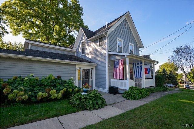 view of front of property with a porch and a front lawn