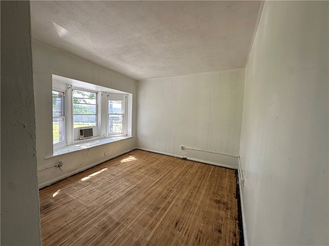 unfurnished room with hardwood / wood-style floors and a textured ceiling