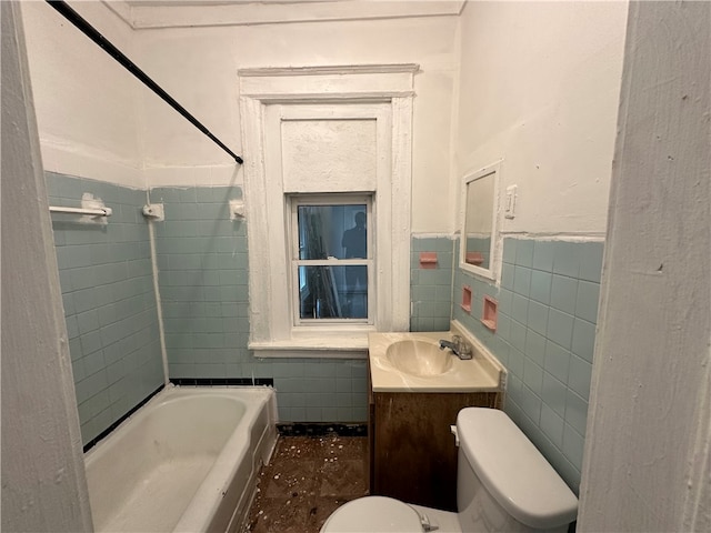 full bathroom with vanity, toilet, tiled shower / bath combo, and tile walls