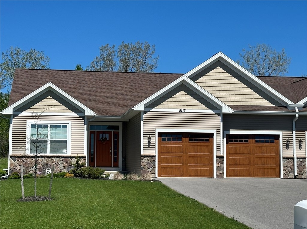 craftsman house featuring a garage and a front lawn