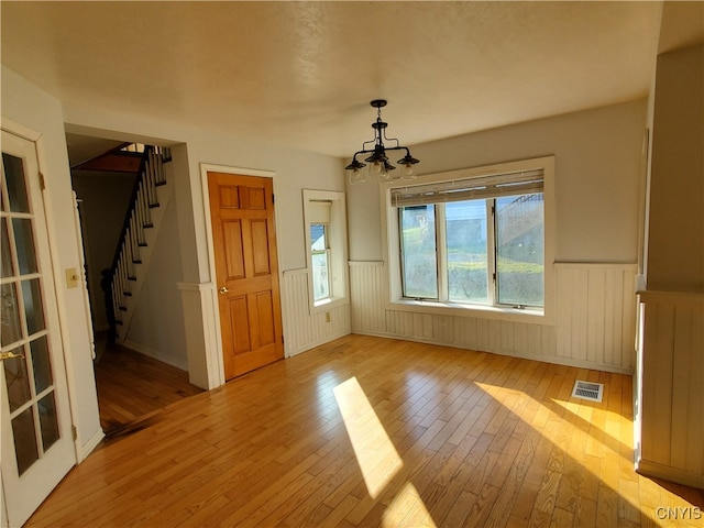 interior space featuring light wood-type flooring and a notable chandelier