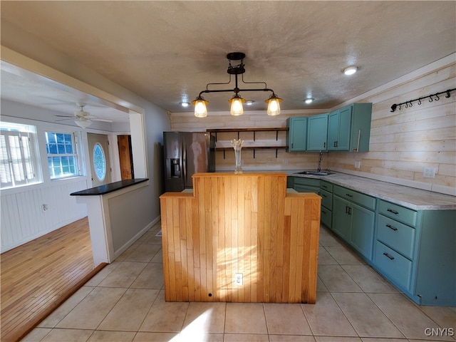 kitchen with decorative light fixtures, fridge with ice dispenser, sink, ceiling fan, and light wood-type flooring