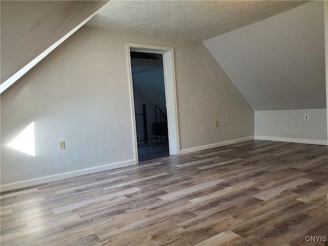 bonus room with a textured ceiling, vaulted ceiling, and hardwood / wood-style flooring