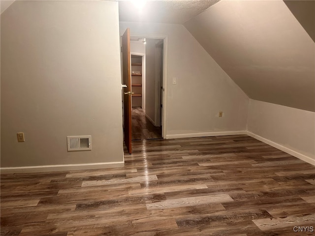 bonus room with lofted ceiling and dark hardwood / wood-style flooring