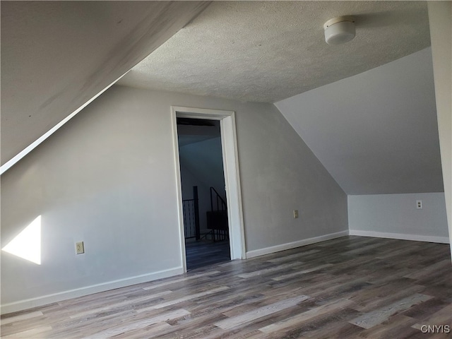 bonus room featuring vaulted ceiling, a textured ceiling, and hardwood / wood-style floors