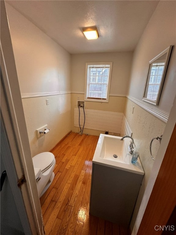 bathroom with vanity, toilet, hardwood / wood-style flooring, and a textured ceiling