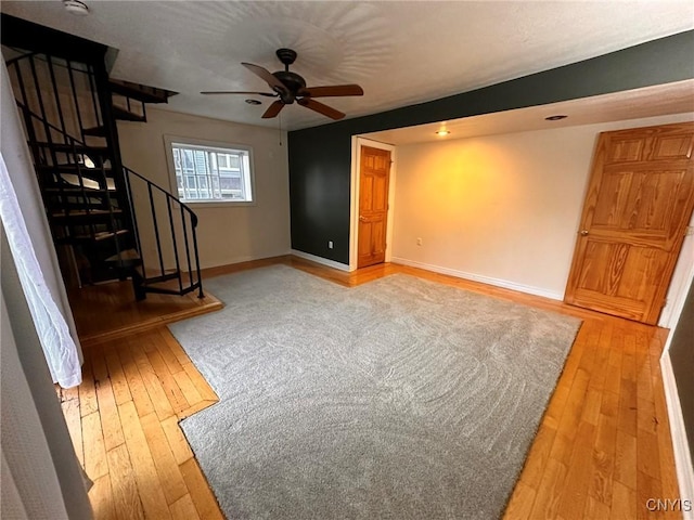 205 S James St, Wilna, NY 13619 - unfurnished living room with light wood finished floors, stairway, a ceiling fan, and baseboards