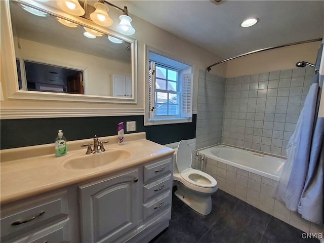 full bathroom with tile patterned floors, toilet, tiled shower / bath combo, and vanity