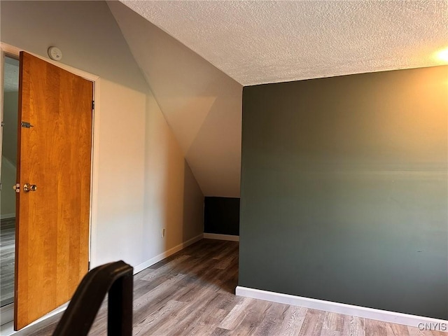205 S James St, Wilna, NY 13619 - additional living space with vaulted ceiling, wood finished floors, a textured ceiling, and baseboards