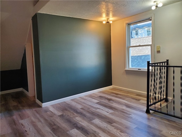 spare room featuring a textured ceiling and wood-type flooring