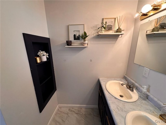 205 S James St, Wilna, NY 13619 - bathroom with marble look tiles, double vanity, and baseboards