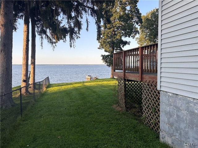 yard at dusk with a deck with water view