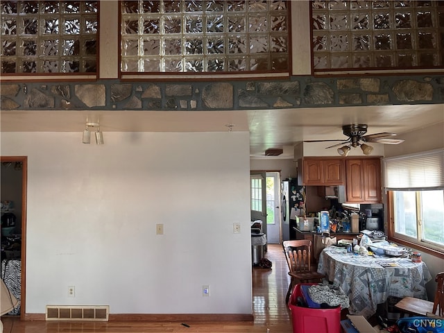 kitchen with ceiling fan, stainless steel refrigerator, and hardwood / wood-style floors