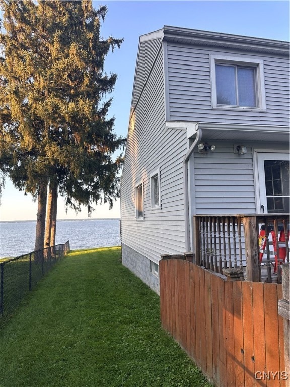 view of property exterior featuring a water view and a yard