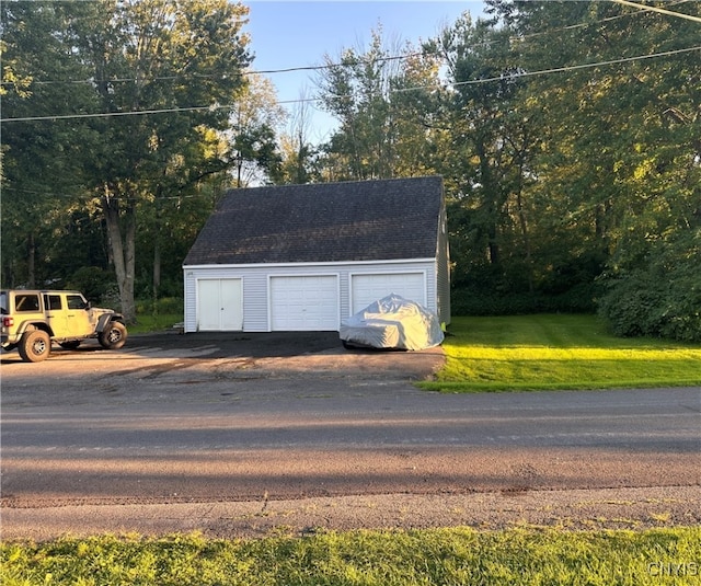 view of outdoor structure featuring a garage and a lawn