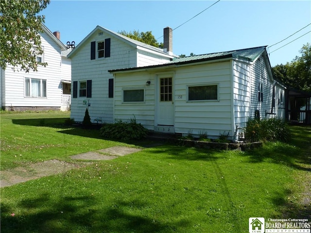 132 Miller St, Sherman, NY 14781 - rear view of property featuring a chimney, metal roof, and a yard