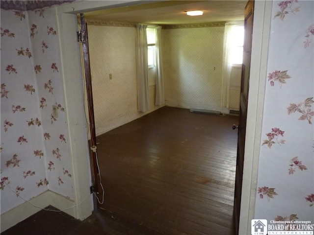 132 Miller St, Sherman, NY 14781 - empty room with wallpapered walls, plenty of natural light, dark wood-type flooring, and baseboards