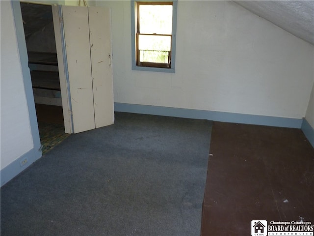 bonus room with vaulted ceiling and carpet floors