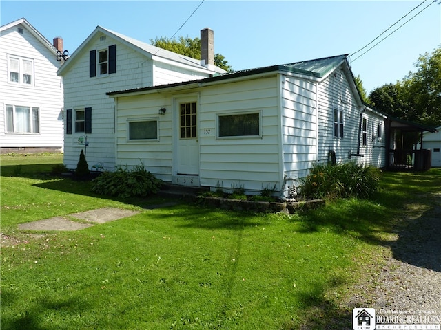 rear view of property featuring a lawn