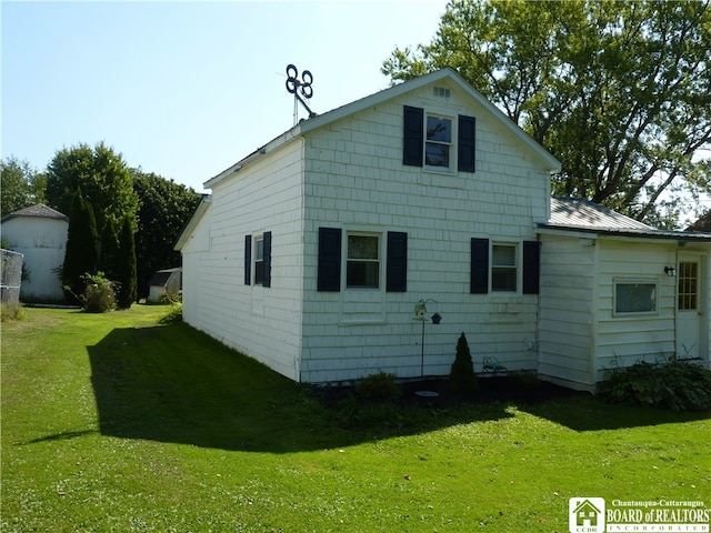 back of property with a yard and a storage unit