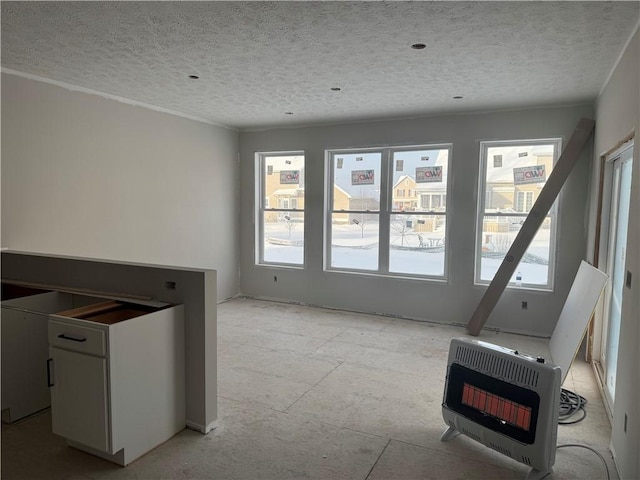 interior space featuring heating unit and a textured ceiling