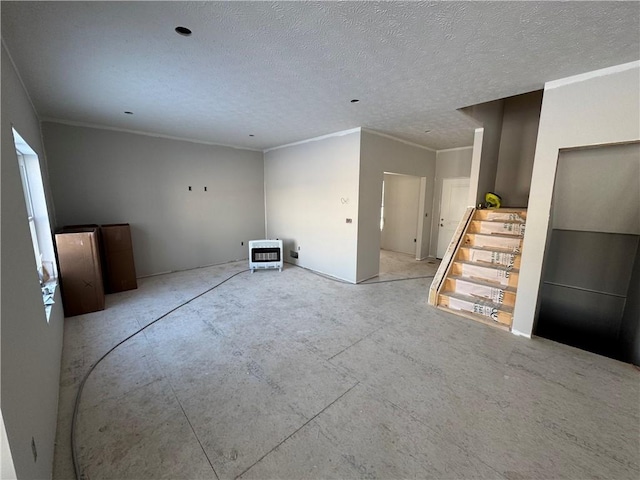 unfurnished room with ornamental molding and a textured ceiling