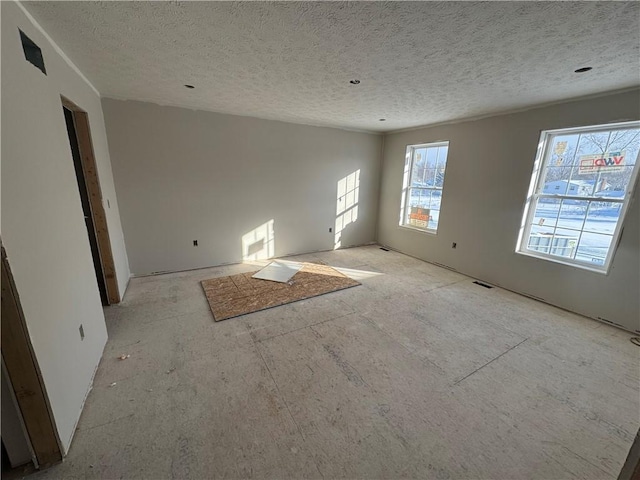 unfurnished room featuring a textured ceiling