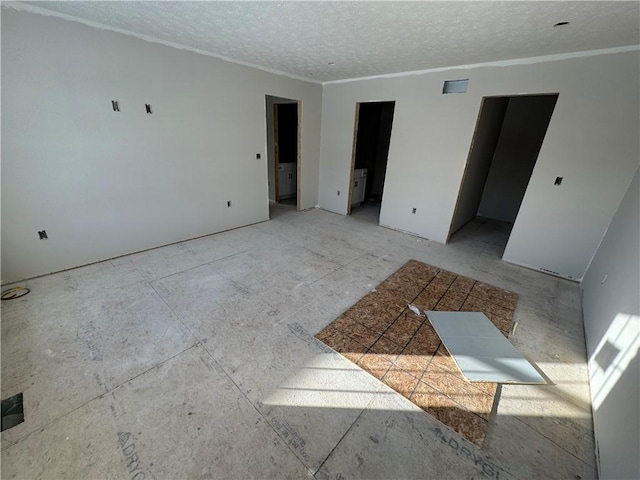 unfurnished room featuring crown molding and a textured ceiling