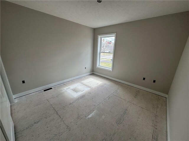 unfurnished room featuring baseboards and a textured ceiling