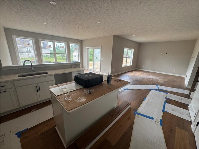 36 Kaye Park Ter, Gates, NY 14624 - kitchen with a textured ceiling, dark wood-style flooring, white cabinetry, open floor plan, and light countertops