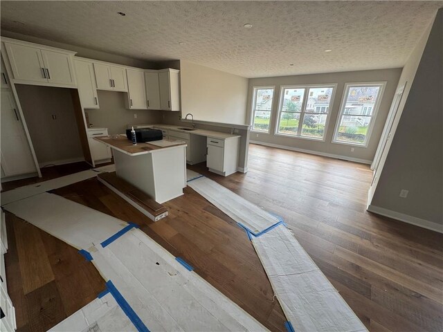 36 Kaye Park Ter, Gates, NY 14624 - kitchen with a center island, a textured ceiling, white cabinets, wood finished floors, and a peninsula
