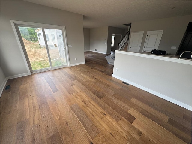 36 Kaye Park Ter, Gates, NY 14624 - unfurnished living room featuring wood finished floors and stairway