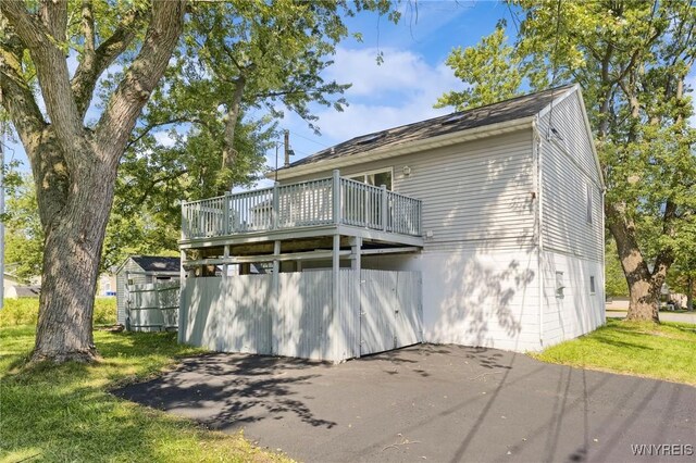 view of front facade with a wooden deck and a front lawn