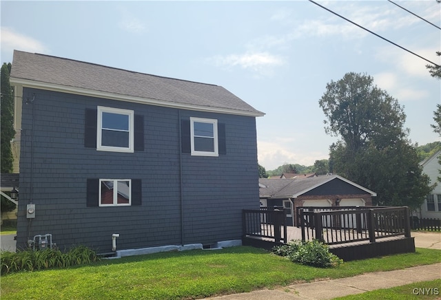 view of side of home featuring a lawn, a garage, and a deck