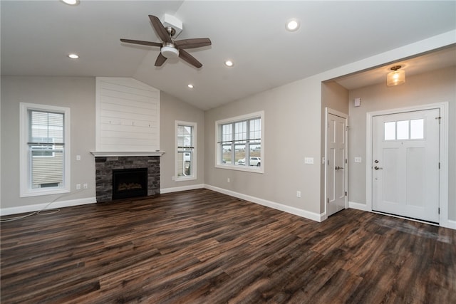 interior space with dark wood-type flooring, ceiling fan, a fireplace, and vaulted ceiling