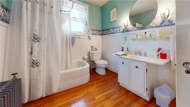 full bathroom with vanity, hardwood / wood-style floors, tile walls, toilet, and shower / bath combo