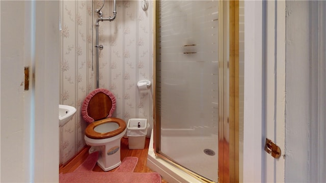 bathroom featuring hardwood / wood-style floors, toilet, and an enclosed shower