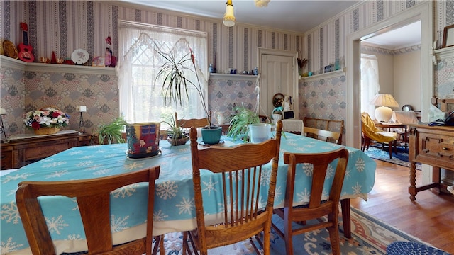 dining room with hardwood / wood-style flooring and crown molding