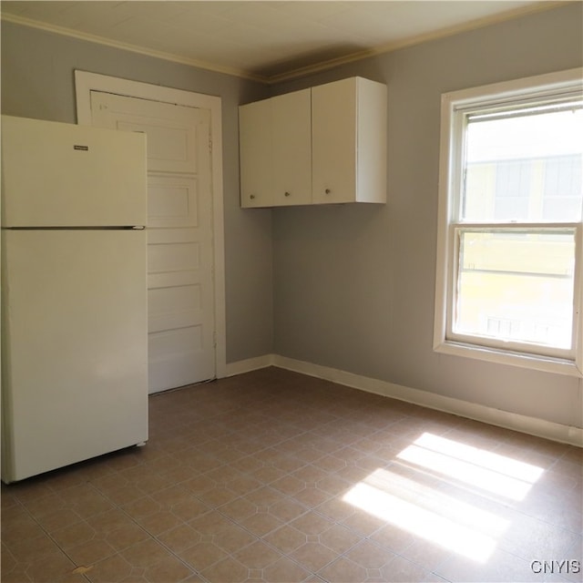 kitchen with crown molding, white refrigerator, and white cabinets