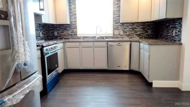 kitchen with white cabinets, backsplash, stainless steel appliances, dark hardwood / wood-style flooring, and sink