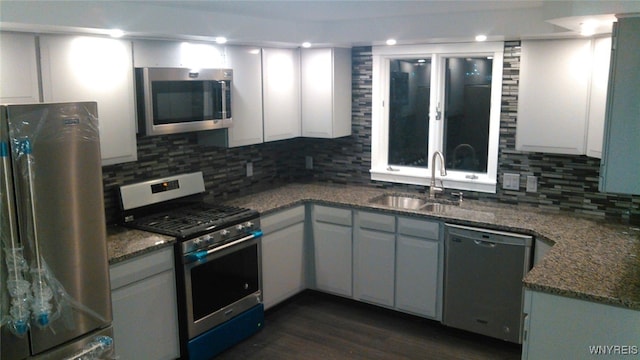 kitchen with white cabinetry, sink, decorative backsplash, dark hardwood / wood-style floors, and appliances with stainless steel finishes