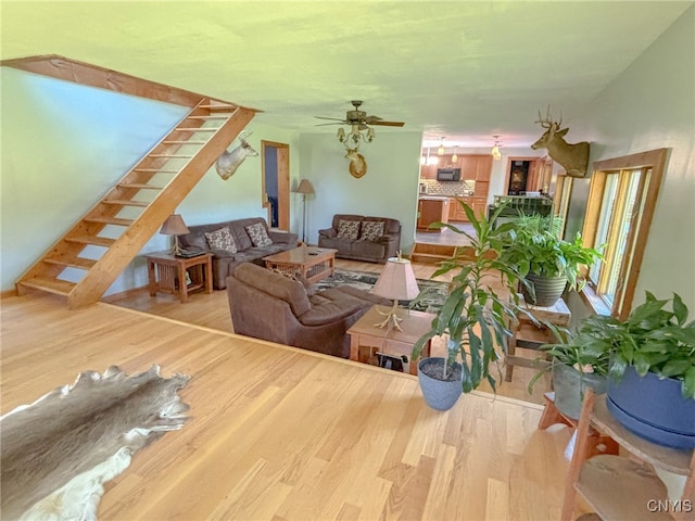 living room with ceiling fan and light hardwood / wood-style flooring