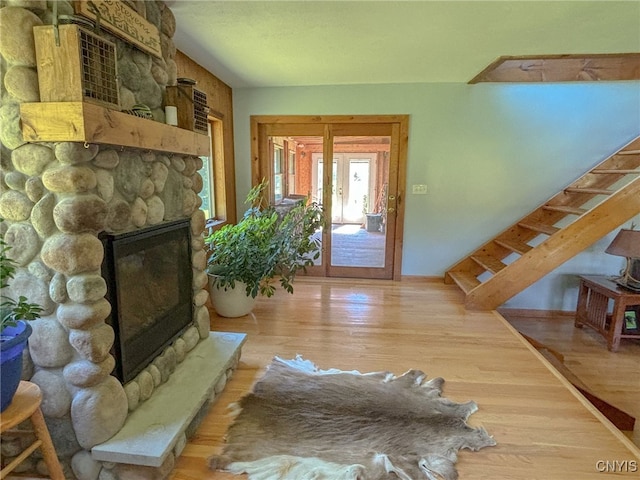 entryway featuring french doors, hardwood / wood-style floors, and a stone fireplace