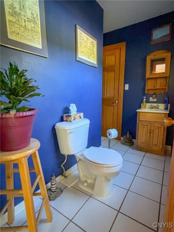 bathroom with toilet, sink, and tile patterned floors