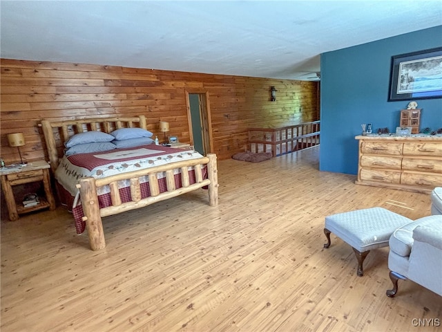 bedroom featuring wood walls and light hardwood / wood-style floors