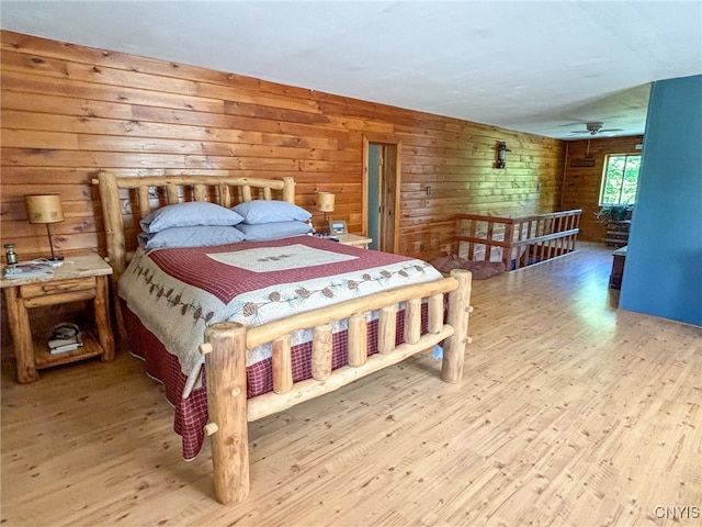 bedroom with hardwood / wood-style floors and wood walls