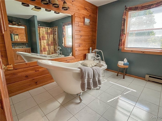 bathroom featuring a wealth of natural light, a baseboard heating unit, wooden walls, and tile patterned floors