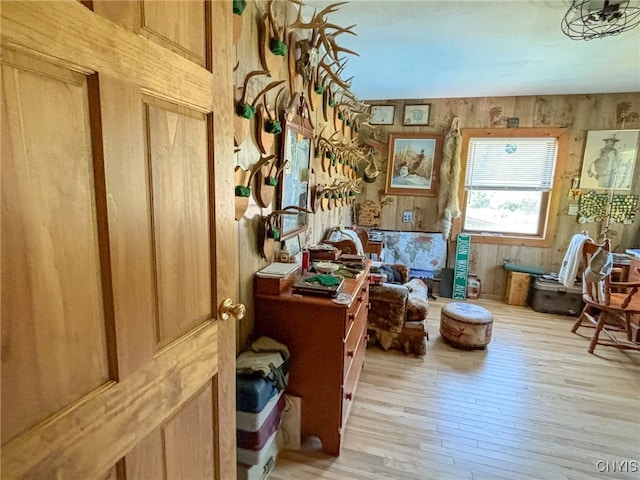 interior space with wood walls and light hardwood / wood-style flooring