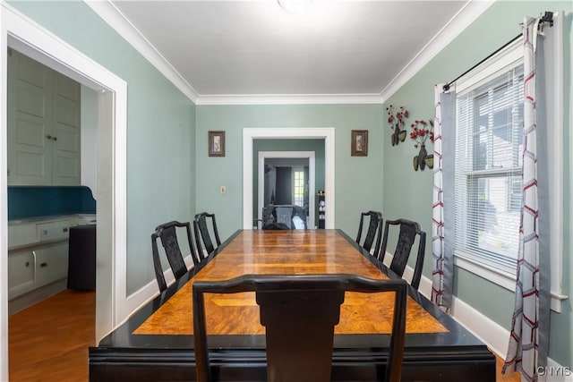 dining space with hardwood / wood-style flooring and ornamental molding