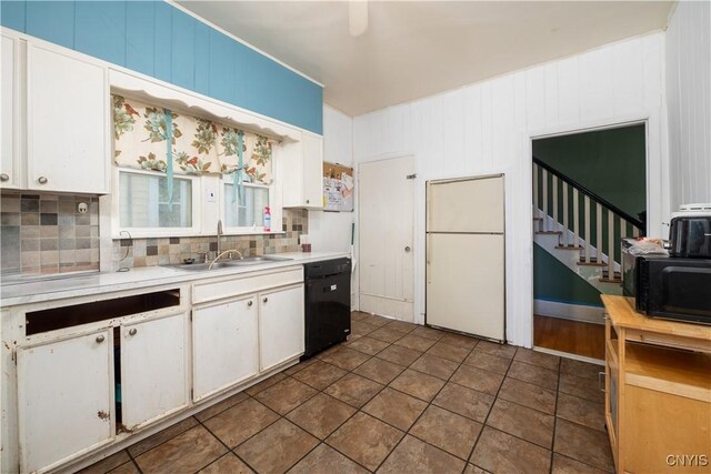 kitchen with white cabinets, backsplash, dark tile patterned floors, sink, and black appliances